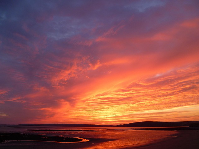 Ruhige Meereswellen am Sandstrand bei Sonnenaufgang